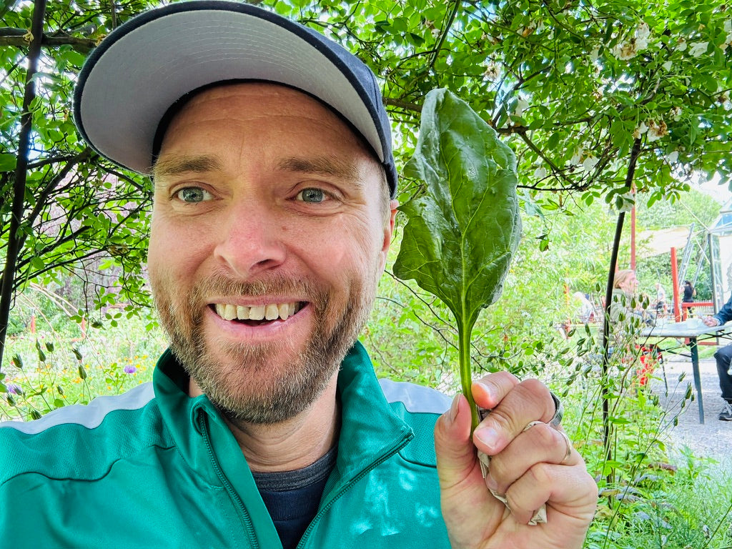 Eric Unevik i naturmiljö, hållande ett blad som symbol för ett naturbaserat och utforskande arbetssätt