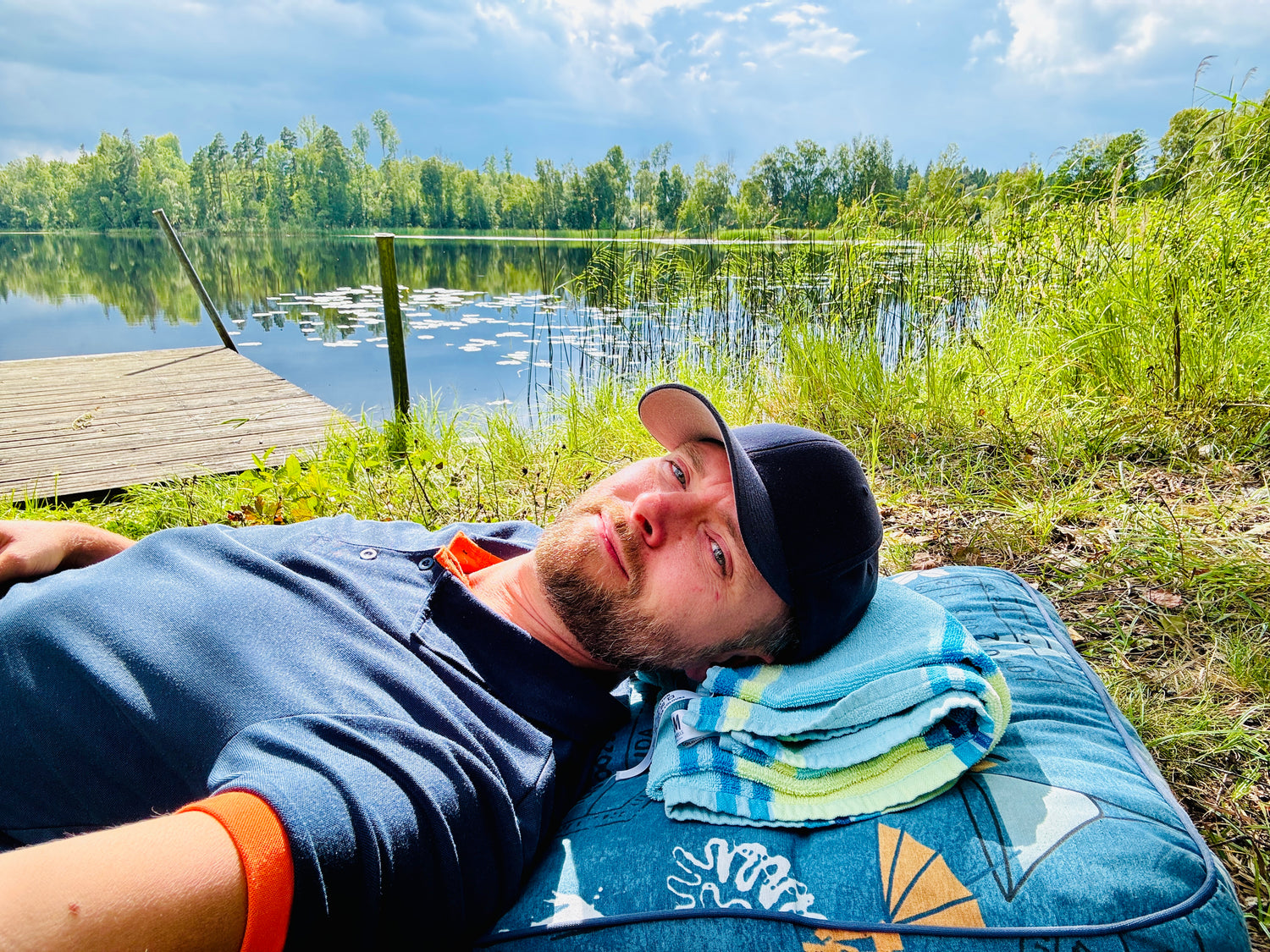 Eric Unevik liggande vid en stilla sjö i naturen under vila och återhämtning